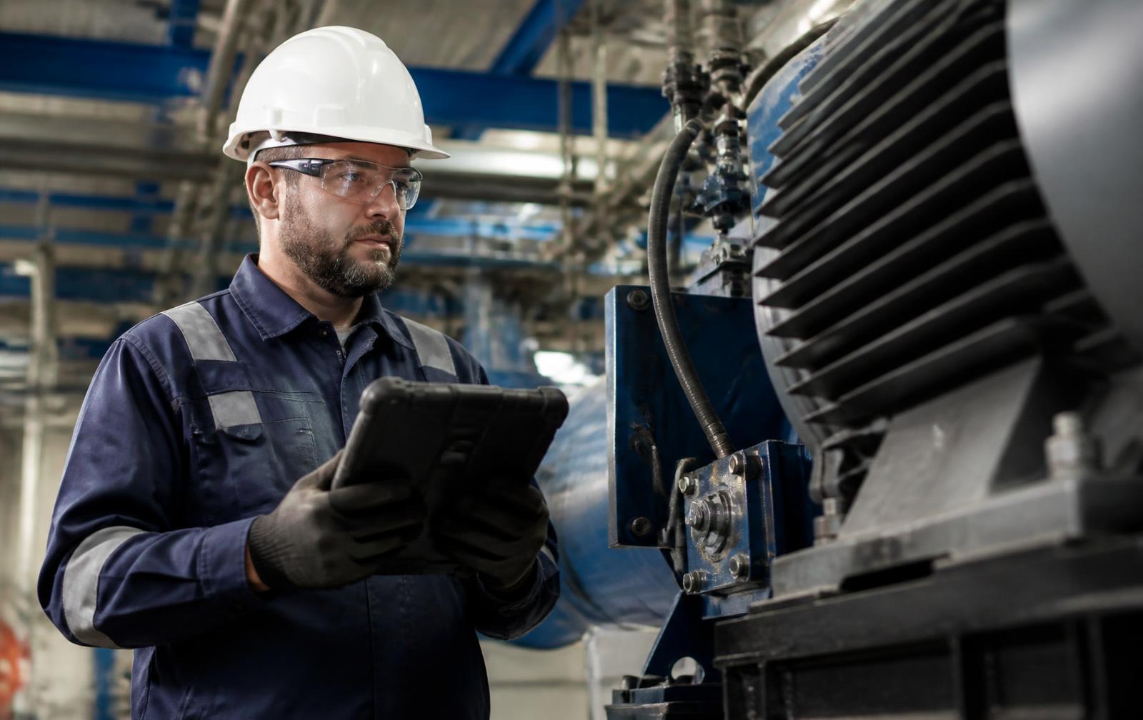 Service technician inspecting a vehicle with a diagnostic tool